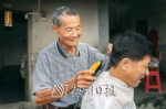 80岁的丘伟曾仍在坚持为周边村民理发。（连志城　摄） - Meizhou.Cn