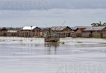 8月18日，在印度东北部阿萨姆邦，人们乘船经过被洪水侵袭的房屋。 （新华社/路透） - 新浪广东
