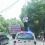 民警罗德平在烈日下托举电线保障车辆通行获赞。（网友拍摄） - 新浪广东