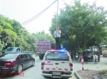 民警罗德平在烈日下托举电线保障车辆通行获赞。（网友拍摄） - 新浪广东