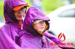 昨日，高明中山路上，一对母女在雨中等红绿灯。/佛山日报见习记者吕润致摄 - 新浪广东