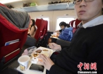 资料图：图为动车组乘客在品尝列车提供的餐食。中新社发 侯宇 摄 - 新浪广东