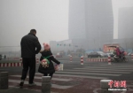 资料图：市民在雾霾中出行。中新社记者 刘关关 摄 - 新浪广东