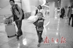 在佛山西站，小朋友帮家人扛着行李进站乘车。南方日报记者 戴嘉信 摄 - 新浪广东
