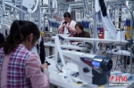 资料图：工人在勉县制衣厂生产线工作。 毛建军 摄 - 新浪广东