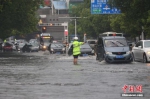 资料图：交警在暴雨中指挥交通。朱华刚 摄 - 新浪广东