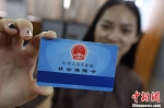 资料图：居民手持社会保障卡。 中新社记者 泱波 摄 - 新浪广东