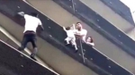 马里移民贾萨玛徒手爬上4楼，救下了悬在空中的孩子。（图片来源：社交网站视频截图） - 新浪广东
