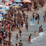 资料图：西班牙贝尼多姆，游客在海滩享受日光浴。 - 新浪广东