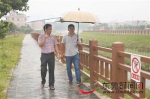 莫文辉（左）和联络员在雨中巡查石水口排渠 东莞时报记者 陈栋 摄 - 新浪广东