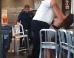 互相厮打中，白衣女经理将她抱起来扔在附近的一张桌子上继续殴打。 - 新浪广东