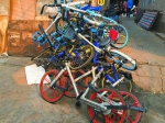 在江门城郊某市场附近的窄巷内，共享单车被堆成一堆 - 新浪广东