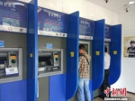 资料图：民众在自动取款机上取钱。中新网记者 李金磊 摄 - 新浪广东