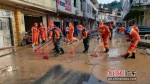 广州消防增援力量清理英德市水边镇主要道路的淤泥。 作者 广州消防 - 中国新闻社广东分社主办