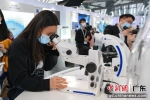 市民在展览上使用显微镜观察蝴蝶标本。 作者 陈骥旻 - 中国新闻社广东分社主办